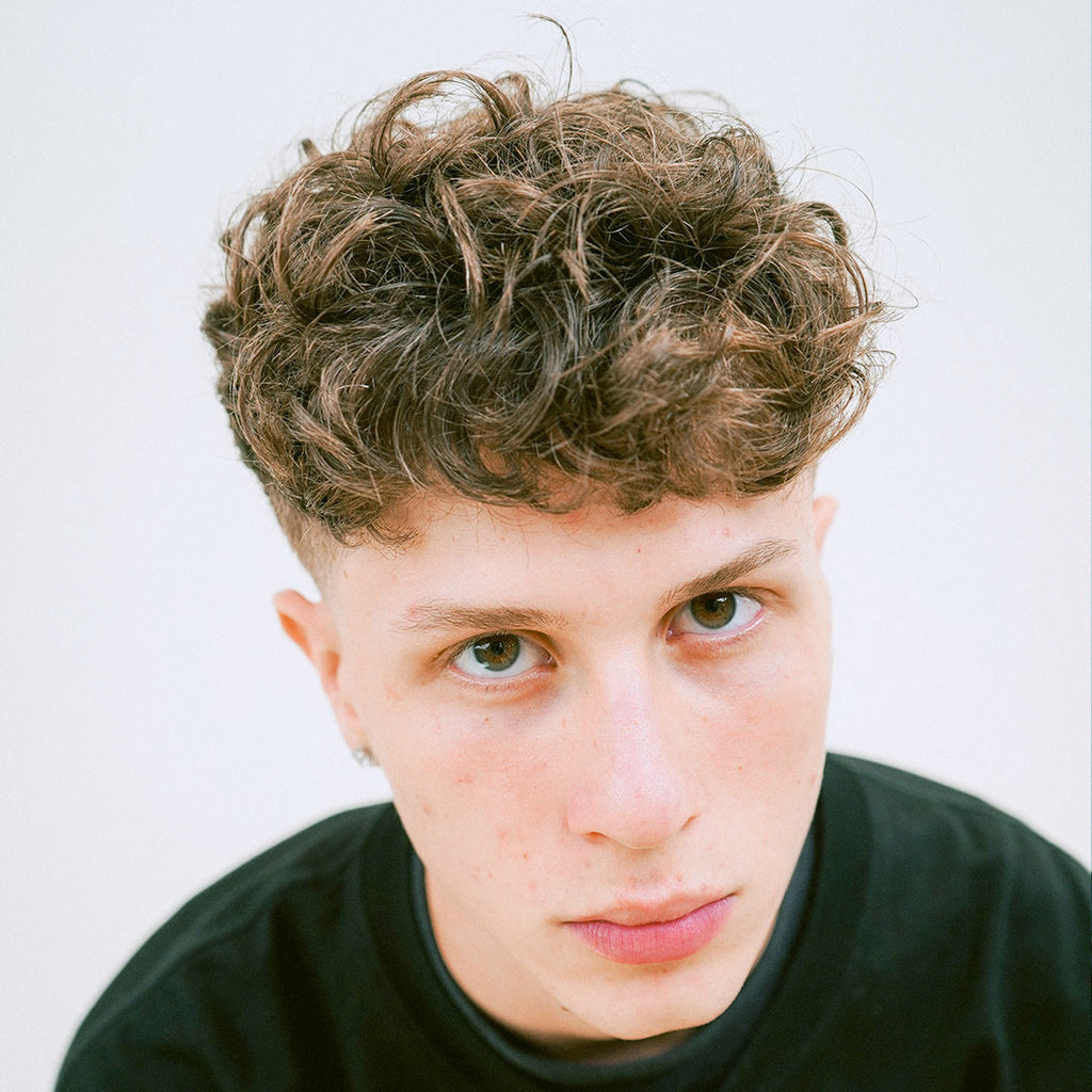 Model with chestnut brown curly hair top view