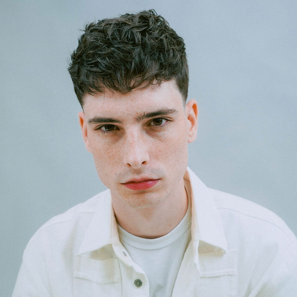 Model with dark textured haircut styled with Ceremony Disorder Sea Salt Spray, showcasing texture
