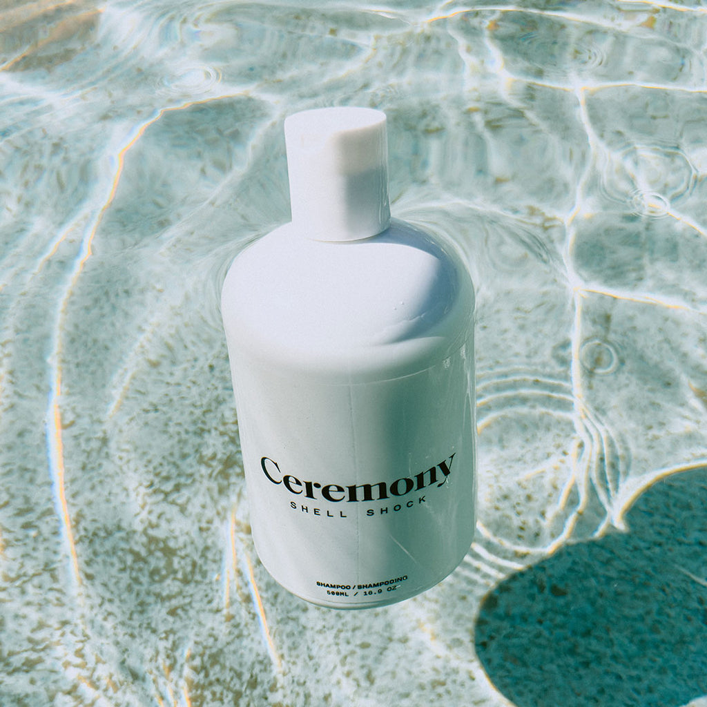 Bottle of Ceremony Shell Shock Shampoo 500 ml floating in water